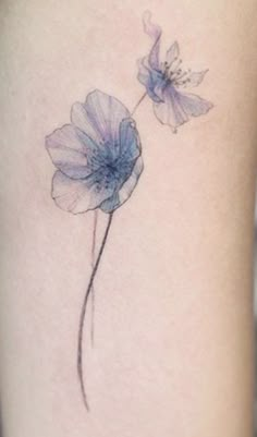 a small tattoo with two flowers on the side of the leg, one is blue and the other is pink