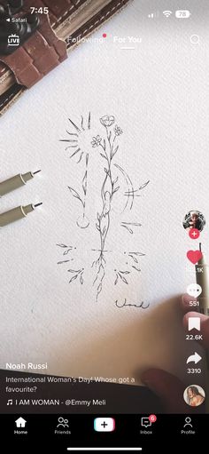 someone is drawing flowers on paper with scissors