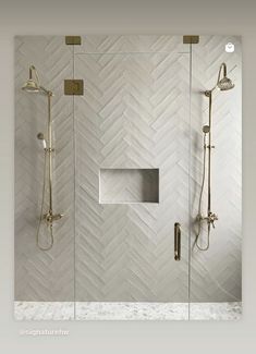 a walk in shower sitting next to a white tiled wall with gold fixtures on it