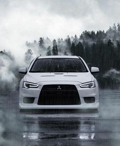 a white car driving down a wet road