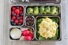 a bento box filled with different types of food and fruit on top of a wooden table