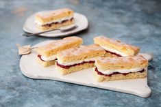 three pieces of cake sitting on top of a cutting board