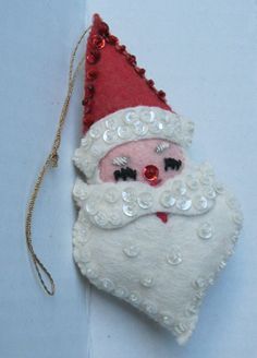 a santa claus ornament hanging from a chain