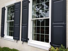 three windows with black shutters and white trim