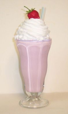 a pink drink with whipped cream and a strawberry on top