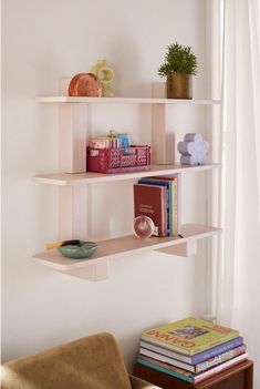 three white shelves with books and vases on them