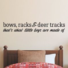 a bedroom with a bed and wall decal that says boys, racks & deer tracks that's what little boys are made of