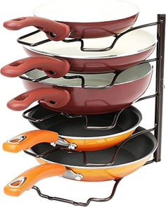 four pans are stacked on top of each other with orange handles and black ones