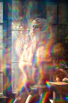 a woman sitting on a bench in front of a window with sunlight streaming through it