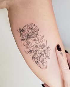 a woman's leg with flowers and a heart tattoo on her left side ribcage