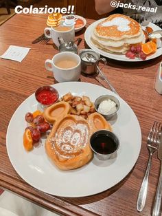 a table with pancakes, fruit and coffee on it