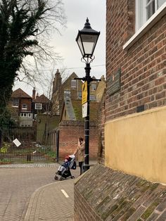 a person pushing a stroller next to a lamp post