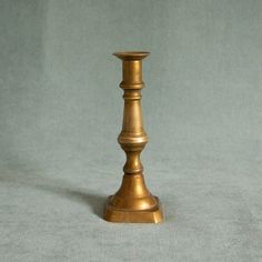 a brass candle holder on a gray background