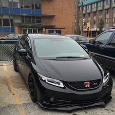 a black car is parked in the parking lot