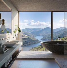 a large bathtub sitting in the middle of a bathroom next to a big window