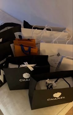 several black and white bags are stacked on top of each other with the word chanel printed on them