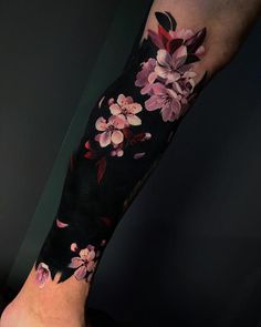 a woman's leg with flowers on it and the bottom half of her arm