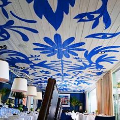 the ceiling is painted with blue and white designs on it, along with two lamps