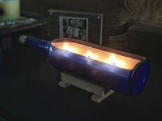 a blue candle holder with candles in it on a table next to a coffee table