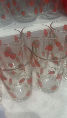 several glass cups with strawberries on them are lined up next to eachother