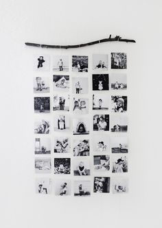 a white wall covered in black and white photos next to a wooden stick with an arrow sticking out of it