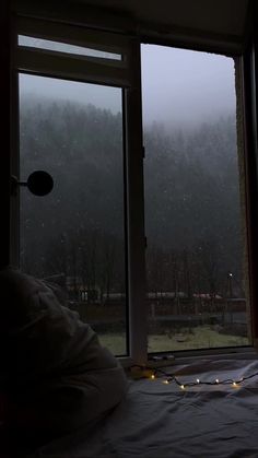 a bed sitting next to a window covered in snow