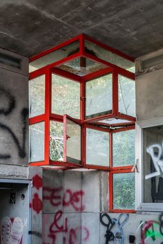 a room with graffiti on the walls and a red light fixture hanging from the ceiling