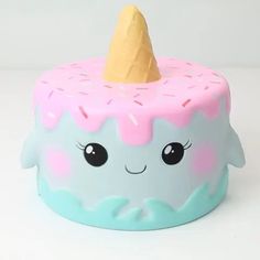 a pink and blue cupcake with a horn on it's top is sitting in front of a white background