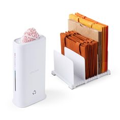 a stack of folders sitting next to a paper dispenser on a white surface