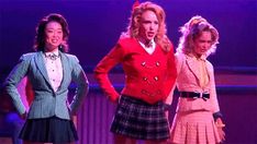 three women in skirts and jackets on stage