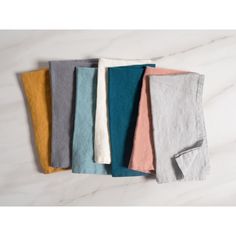 five different colored napkins sitting next to each other on a white marble counter top