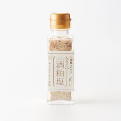 a bottle filled with sand sitting on top of a white table