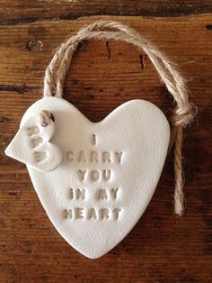 a ceramic heart with the words i carry you in my heart hanging on a rope