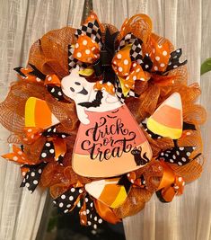 a trick or treat wreath hanging on the front door