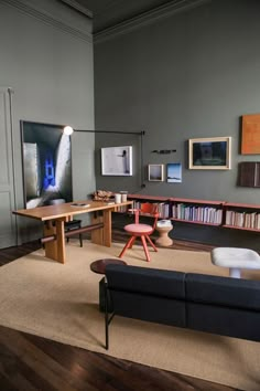 a living room filled with furniture and bookshelves next to a wall covered in pictures