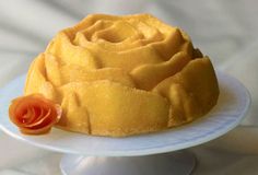 a bundt cake sitting on top of a white plate with a flower in the middle