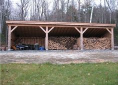 a large pile of wood sitting in the middle of a yard next to a building