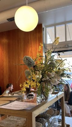 a wooden table topped with lots of vases filled with flowers