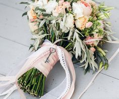 a bridal bouquet on the ground with ribbons