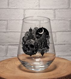 a glass with a skull on it sitting on top of a wooden table