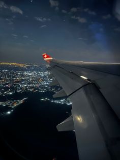 the wing of an airplane flying over a city at night