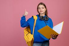 a woman in a blue hoodie is holding a yellow folder and thumbs up