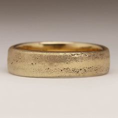 a close up of a gold ring on a white surface