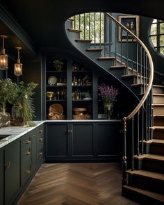 an elegant kitchen with dark green cabinets and wood floors, along with a spiral staircase