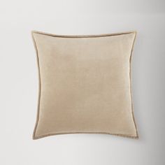 a beige pillow sitting on top of a white wall