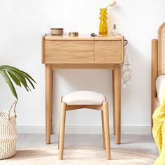 a wooden desk with a white chair next to it and a yellow blanket on the floor