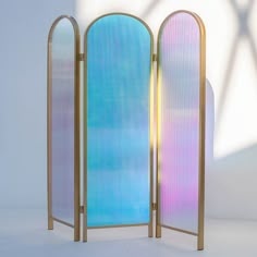 a room divider made out of metal and glass with rainbow colored panels on the sides