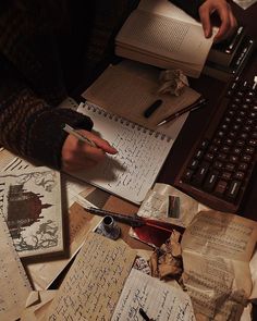 someone is writing on paper and using a typewriter to do some work with them