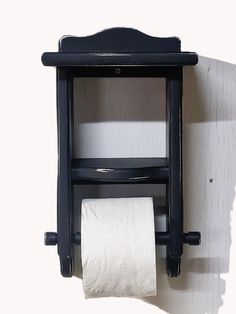 an old fashioned toilet paper dispenser on a white wall with a roll of toilet paper hanging from it's holder