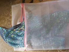 two bags sitting on top of a wooden floor next to a bag with sequins